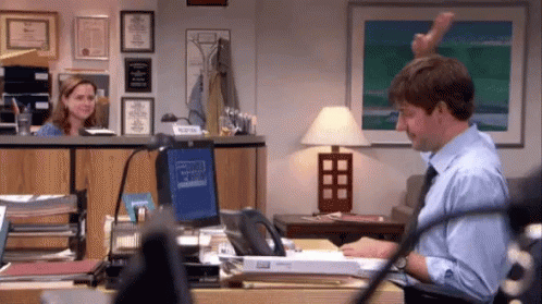 animated gif with a video from the show The Office with a man and a woman high giving in the distance